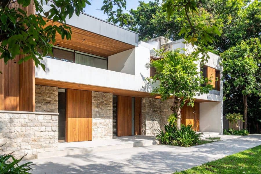 Modern two-storey investment property with a stylish stone and timber fa&ccedil;ade, surrounded by greenery &mdash; representing the benefits of an Investment Loan with Elevate Financial.